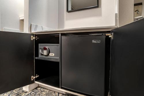 a kitchen with a black refrigerator and a microwave at Sheraton Suites Old Town Alexandria in Alexandria