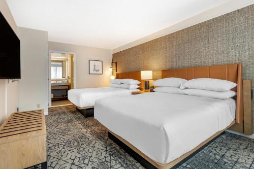 a hotel room with two beds and a television at Sheraton Suites Old Town Alexandria in Alexandria