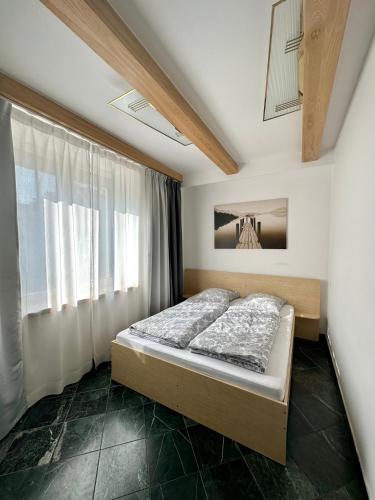 a bedroom with a bed and a window at Zidinio Liepsnele in Palanga
