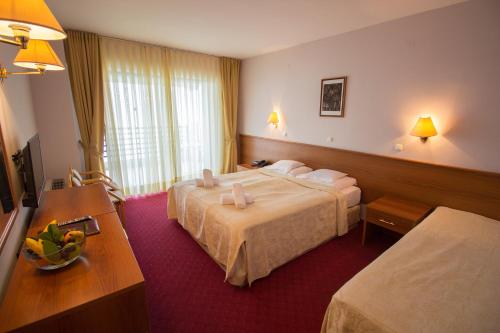 um quarto de hotel com duas camas e uma mesa em Hotel Bellevue - Metropol Lake Resort em Ohrid