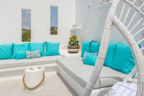 a porch with blue pillows and a swing at Kapetan Giannis Suite in Adamas