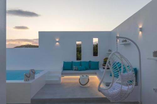 a white bathroom with a bench and a tub at Kapetan Giannis Suite in Adamas