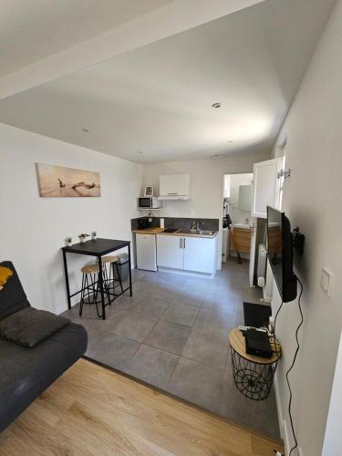 ein Wohnzimmer und eine Küche mit einer Couch und einem Tisch in der Unterkunft Le Castetnau - securise - Proche Halles de Pau in Pau