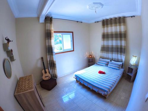 a bedroom with a bed and a guitar in it at Villa Essaouira Mogador in Ounara