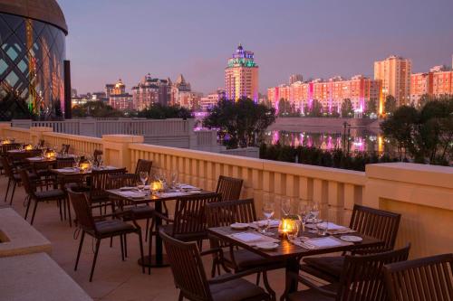 a row of tables on a balcony with a city skyline at The St. Regis Astana in Astana