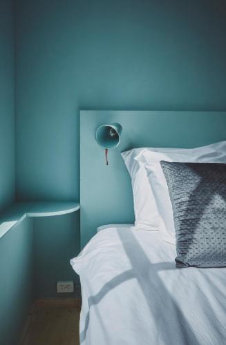 a blue bedroom with a white bed with a blue wall at B&B Maas en Heuvel Maastricht in Maastricht