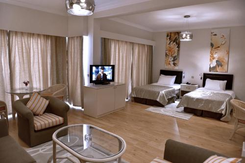 a living room with two beds and a television at Jasmine Court Hotel & Casino in Kérynia
