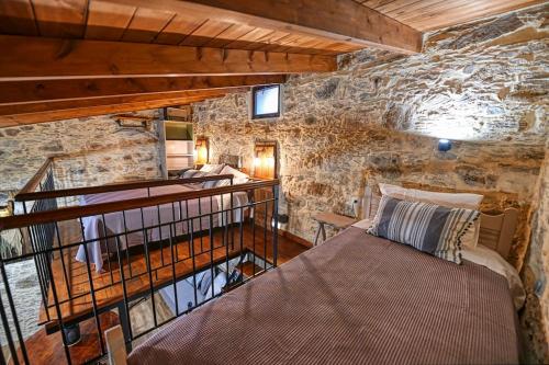 1 dormitorio con 1 cama en una pared de piedra en PefkoPetro Loft, en La Canea