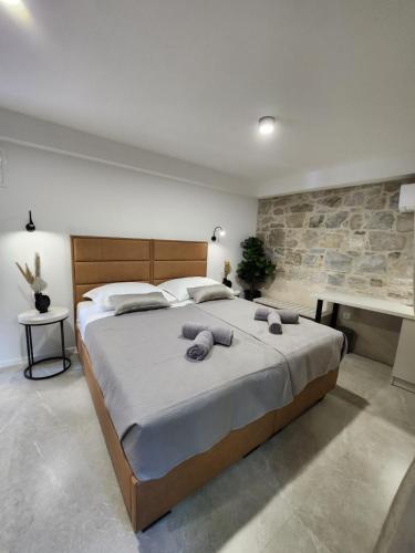 a bedroom with a large bed and a stone wall at Rio Luxury Rooms in Split