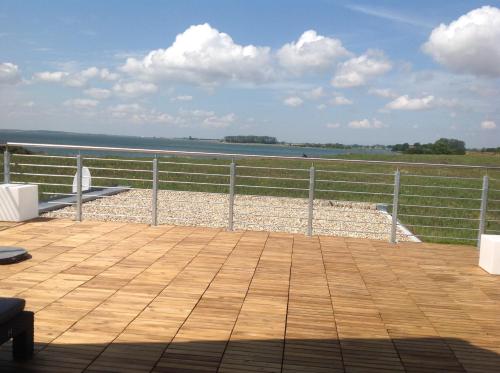 a wooden deck with a view of the water at Glewitz Am Alten Fährhaus in Garz-Rügen