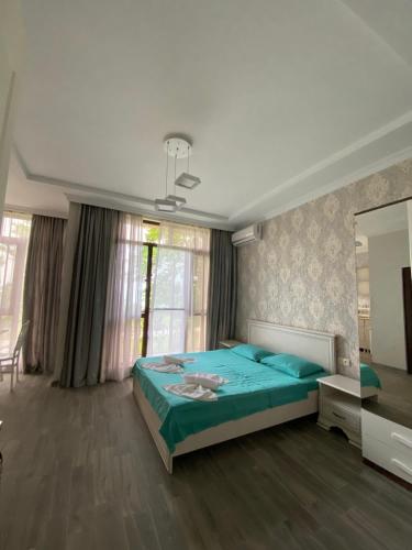 um quarto com uma cama azul e um espelho em House on Moryakov 55 em Chakvi