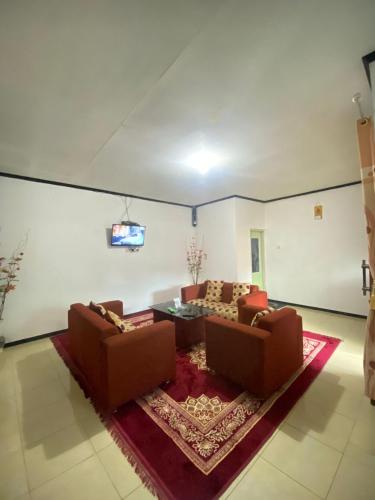 ein Wohnzimmer mit 2 Sofas und einem Tisch in der Unterkunft Homestay Ulya 2 in Diyeng