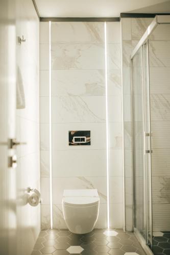 a bathroom with a toilet and a glass shower at QUALA HOTELS & LOUNGE in Aksaray