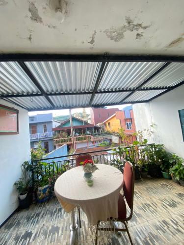 eine Terrasse mit einem Tisch und Stühlen auf dem Balkon in der Unterkunft Homestay Ulya 2 in Diyeng