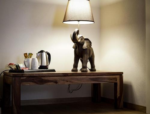 a statue of an elephant holding a lamp on a table at Sella&Mosca Casa Villamarina in Alghero