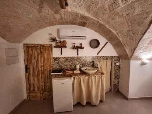 uma cozinha com um balcão e um lavatório num quarto em Nene' em Fasano
