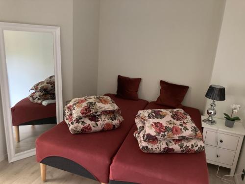 a red couch with two pillows on it in front of a mirror at Free parking central 2bedrooms with terrace in Ålesund