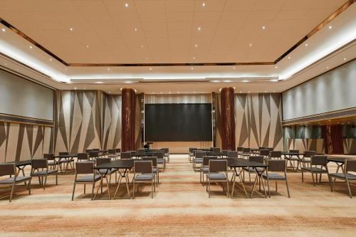 a conference room with tables and chairs and a screen at The Westin Wenzhou in Wenzhou