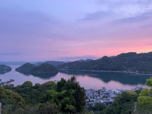 a view of a lake with houses and mountains at 浪漫宿花町 in Mitarai