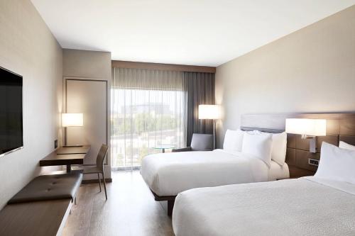 AC Hotel by Marriott Irvine tesisinde bir odada yatak veya yataklar