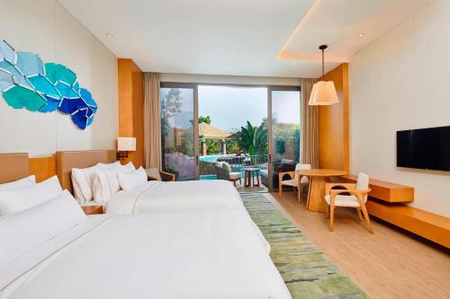 a hotel room with two beds and a flat screen tv at The Westin Shimei Bay Resort in Wanning