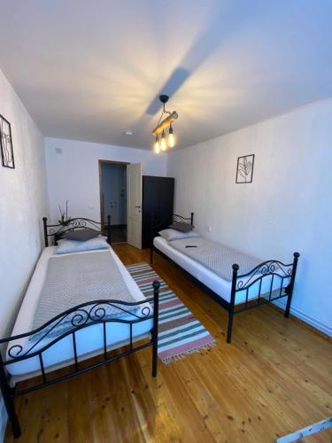2 camas en una habitación con suelo de madera en Taverna Sasului en Bazna