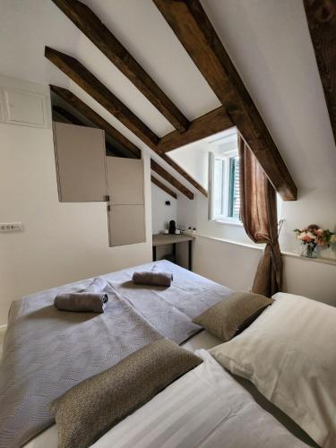 a bedroom with a large bed with two pillows on it at Rio Luxury Rooms in Split