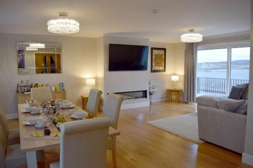 a dining room and living room with a table and chairs at Grimisdale Guest House in Leverburgh