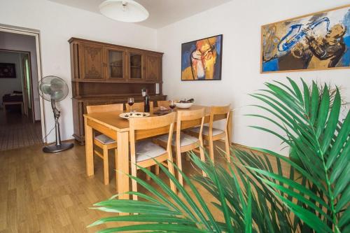 une salle à manger avec une table en bois et une plante dans l'établissement Vila Labod, Unique Villa At The Lake, à Most na Soči