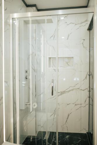 a shower with a glass door in a bathroom at QUALA HOTELS & LOUNGE in Aksaray
