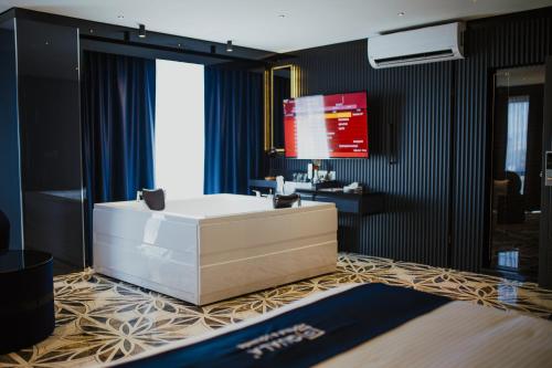 a bathroom with a tub and a tv on a wall at QUALA HOTELS & LOUNGE in Aksaray
