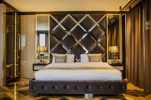 a bedroom with a large bed with a large headboard at QUALA HOTELS & LOUNGE in Aksaray