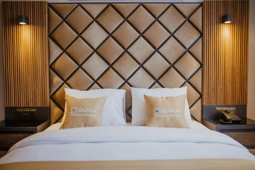 a bed with two pillows on top of it at QUALA HOTELS & LOUNGE in Aksaray