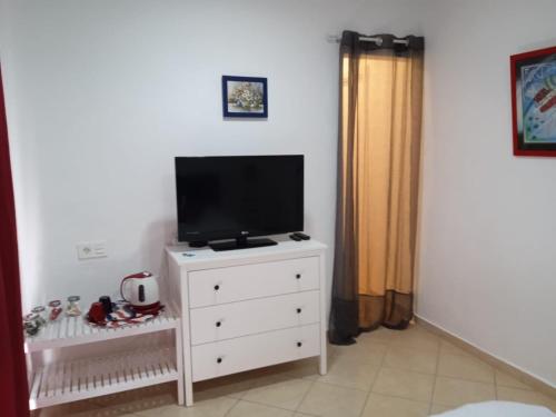 um quarto com uma televisão numa cómoda em La Rana Azul em Vélez-Málaga