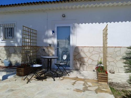 um pátio com uma mesa e cadeiras em frente a uma casa em La Rana Azul em Vélez-Málaga