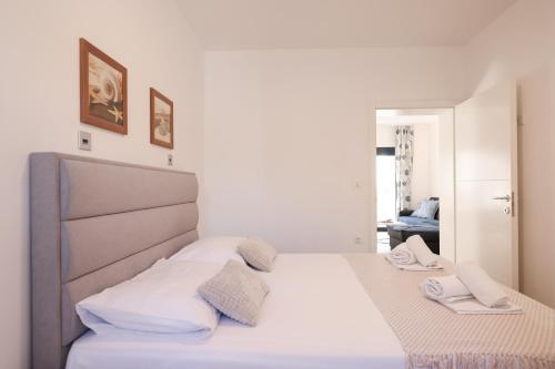 a bedroom with a bed with white sheets and pillows at Apartments Mato in Zadar