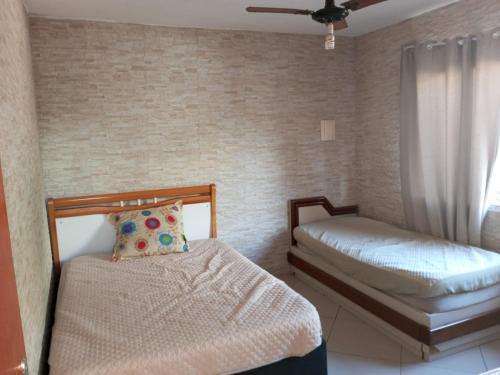um quarto com 2 camas individuais e uma janela em Casa Temporada em Serra