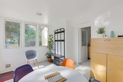 パレゾーにあるMaison avec jardin et jacuzzi proche Polytechniqueのテーブルと椅子、窓が備わる客室です。