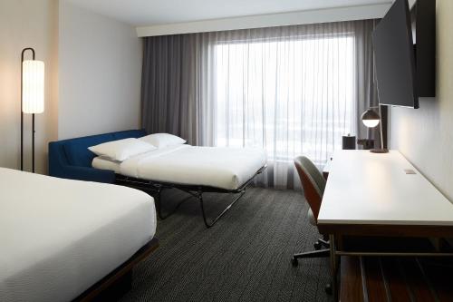 a hotel room with two beds and a window at Courtyard Montreal Midtown in Montréal