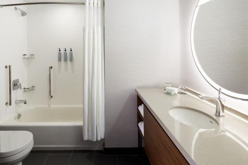 a bathroom with a sink and a tub and a toilet at Courtyard Montreal Midtown in Montréal