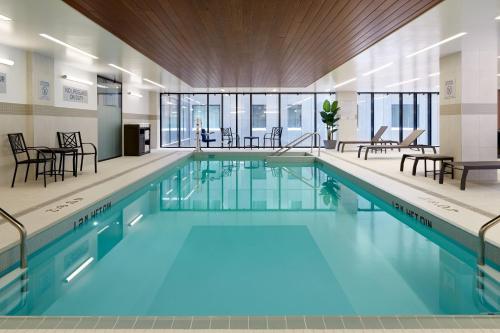 - une piscine d'eau bleue dans un bâtiment dans l'établissement Courtyard by Marriott Montreal Midtown, à Montréal