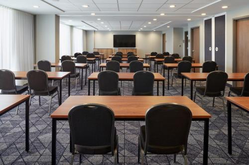 an empty room with tables and chairs and a projection screen at Courtyard Montreal Midtown in Montréal