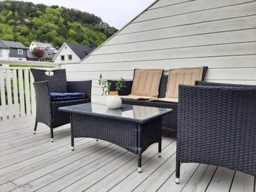 a patio with a table and chairs on a deck at Apartments with parking and terrace in Ålesund