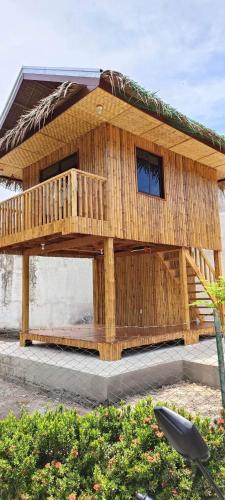 a wooden house with a deck on top of it at Brigitte´s Rental House in Dauin
