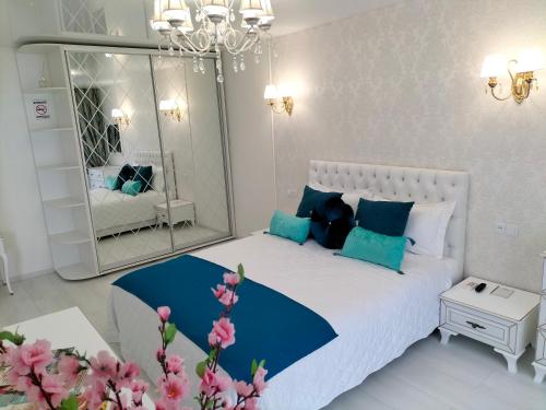 Dormitorio blanco y azul con espejo grande en White Apartment, en Dnipro