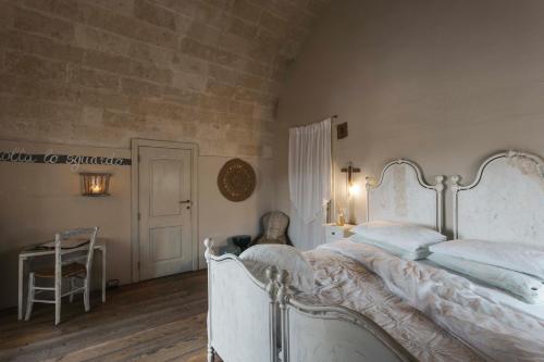 een slaapkamer met een wit bed en een tafel bij Corte San Leonardo in Matera