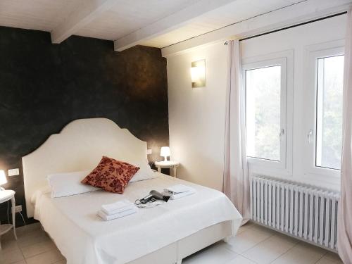 a bedroom with a white bed and a window at Locanda Divinis in Cerea