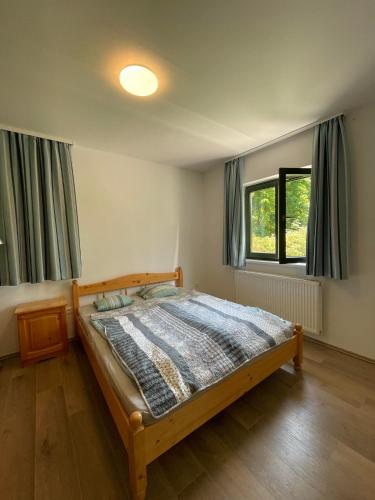 a bedroom with a bed and two windows at Agroger Üdülő in Balatonudvari