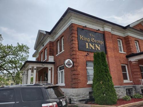 a car parked in front of a brick building at The King George Inn in Cobourg
