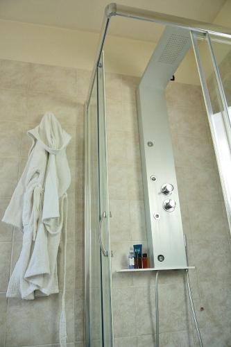 a shower with a glass door and a mirror at Locanda Divinis in Cerea